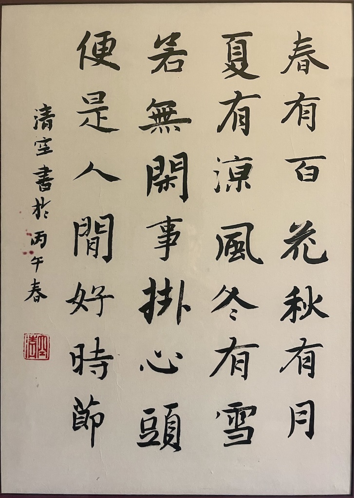 Black sumi ink formal script calligraphy on rice paper, with each line of the following poem written top-down, right to left. 春有百花秋有月 夏有涼風冬有雪 若無閑事掛心頭 便是人間好時節